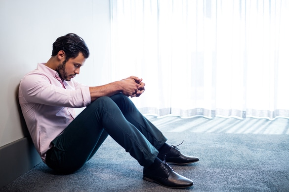 Sad man sitting on the floor